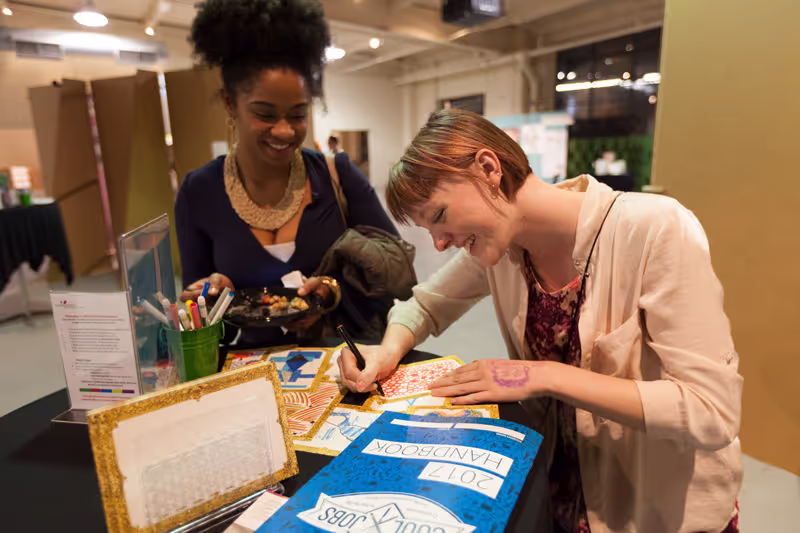 A woman signing a book at a table